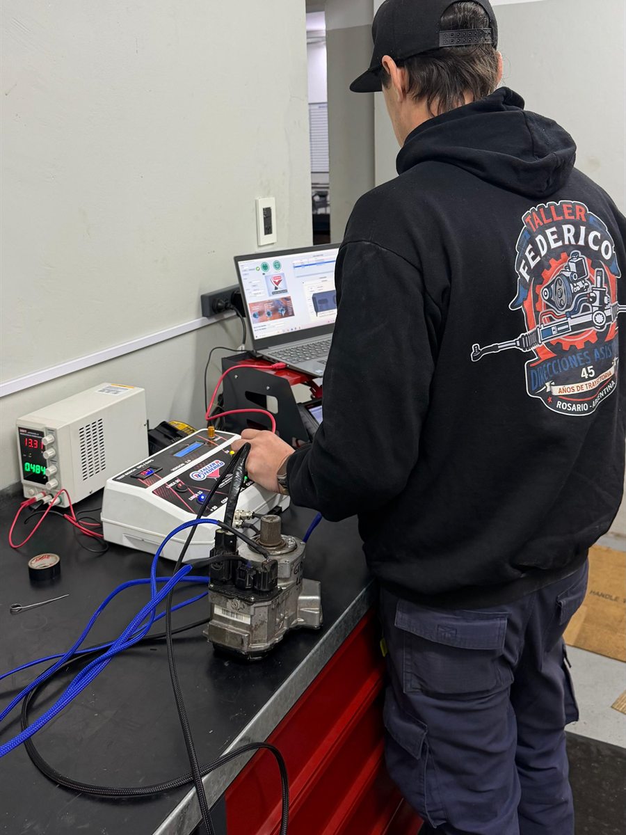 Técnico de Taller Federico probando una unidad de dirección en el banco de pruebas del taller